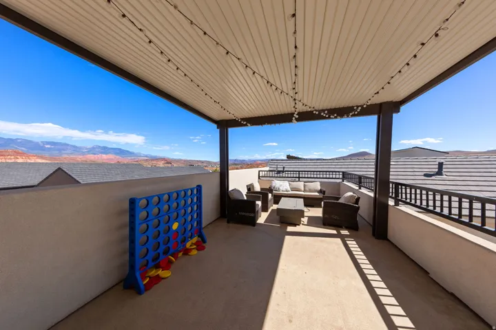 Covered patio with a smooth concrete surface, supported by dark structural posts
