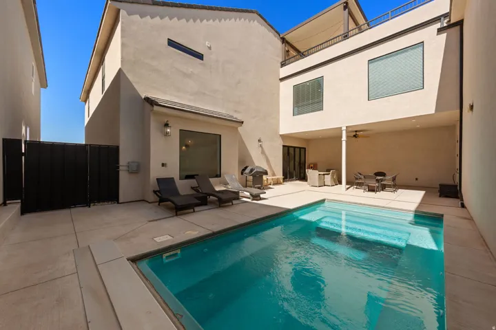 Private courtyard with a built-in swimming pool, a covered patio with a ceiling fan, and a second-level open-air balcony