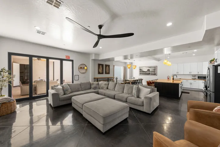 Open-concept living space featuring polished concrete flooring, a modern kitchen with a large island, and a dining area