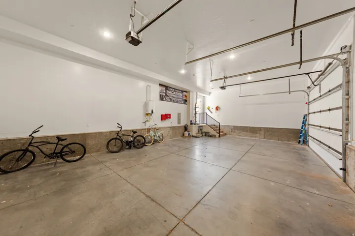 Spacious garage with exposed concrete flooring, white walls, and an overhead door