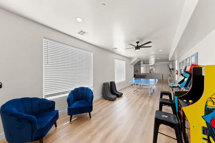 Expansive entertainment space featuring wood-finish flooring, recessed lighting, and a ceiling fan