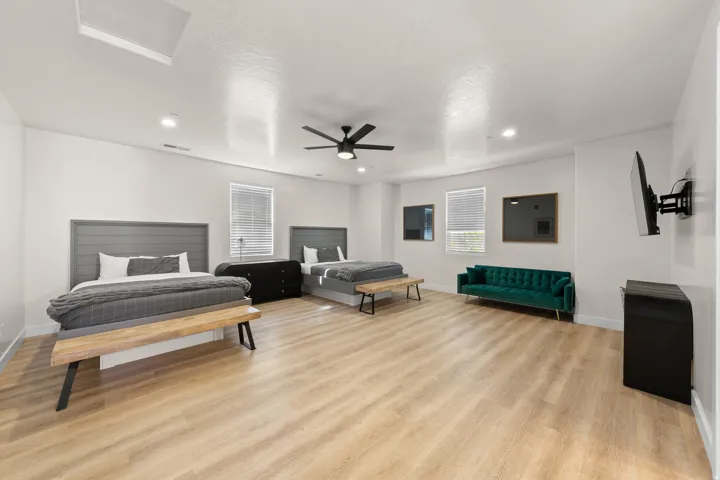 Expansive room featuring wood-finish flooring, recessed lighting, and a ceiling fan