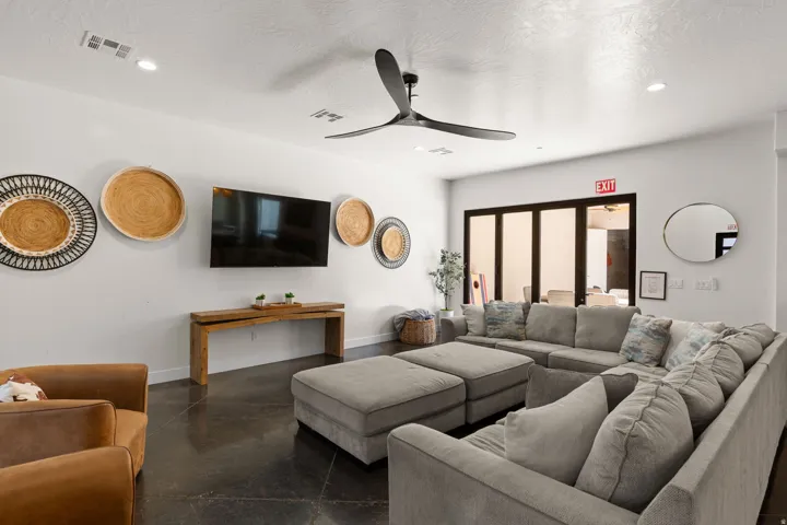 Polished concrete flooring, recessed ceiling lighting, ceiling fan, and folding glass-panel doors