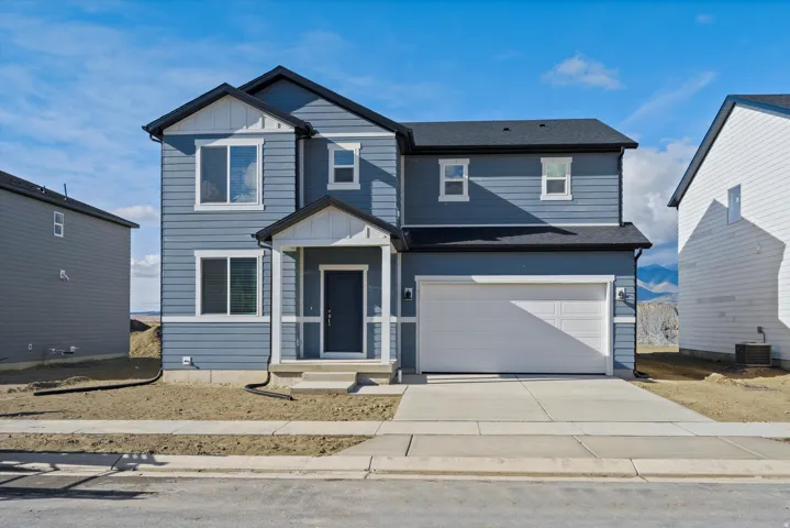 Two-story exterior with siding, attached garage, and covered entryway