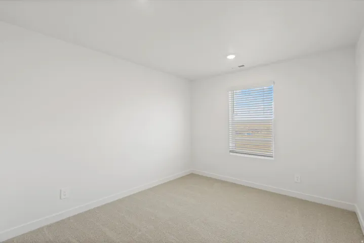 **DISCLAIMER** Interior package may vary. Recessed ceiling lighting, a single window with horizontal blinds, neutral wall paint, and light-toned carpet flooring