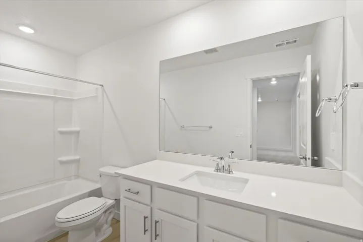 **DISCLAIMER** Interior package may vary. White vanity with a single basin, stainless steel faucet, and expansive wall-mounted mirror