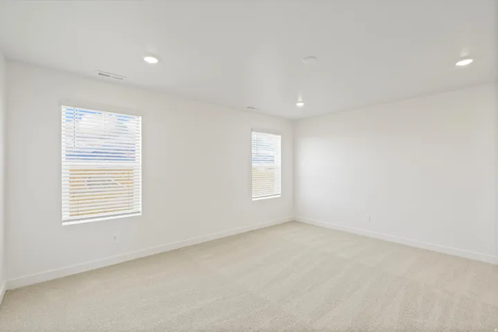 **DISCLAIMER** Interior package may vary. Neutral-toned carpeting, white walls, two windows with blinds, and recessed ceiling lighting