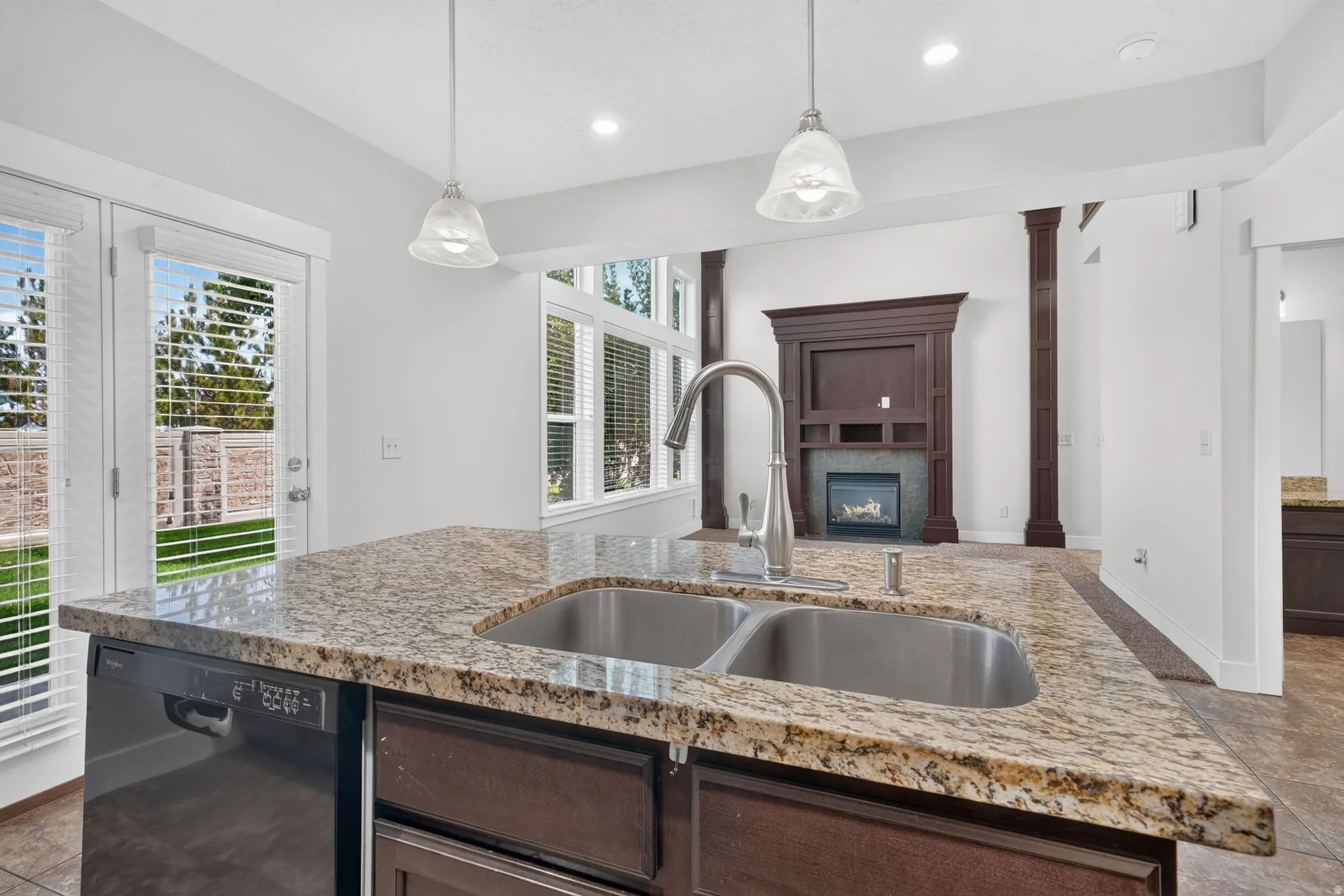Kitchen island with a double basin stainless steel sink, a pull-down faucet, and granite countertops