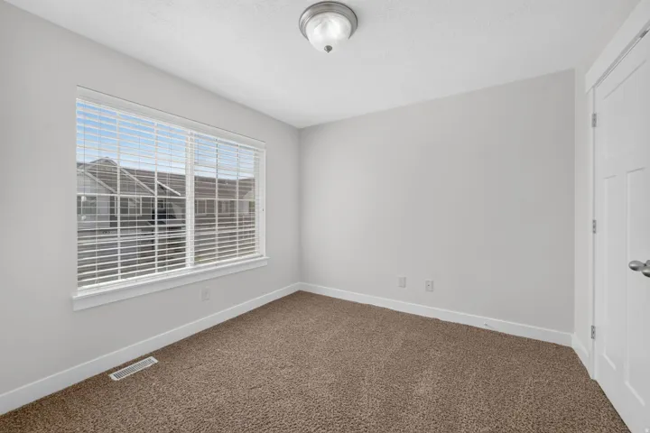 Broadloom carpeting, white trim, and a window with horizontal blinds
