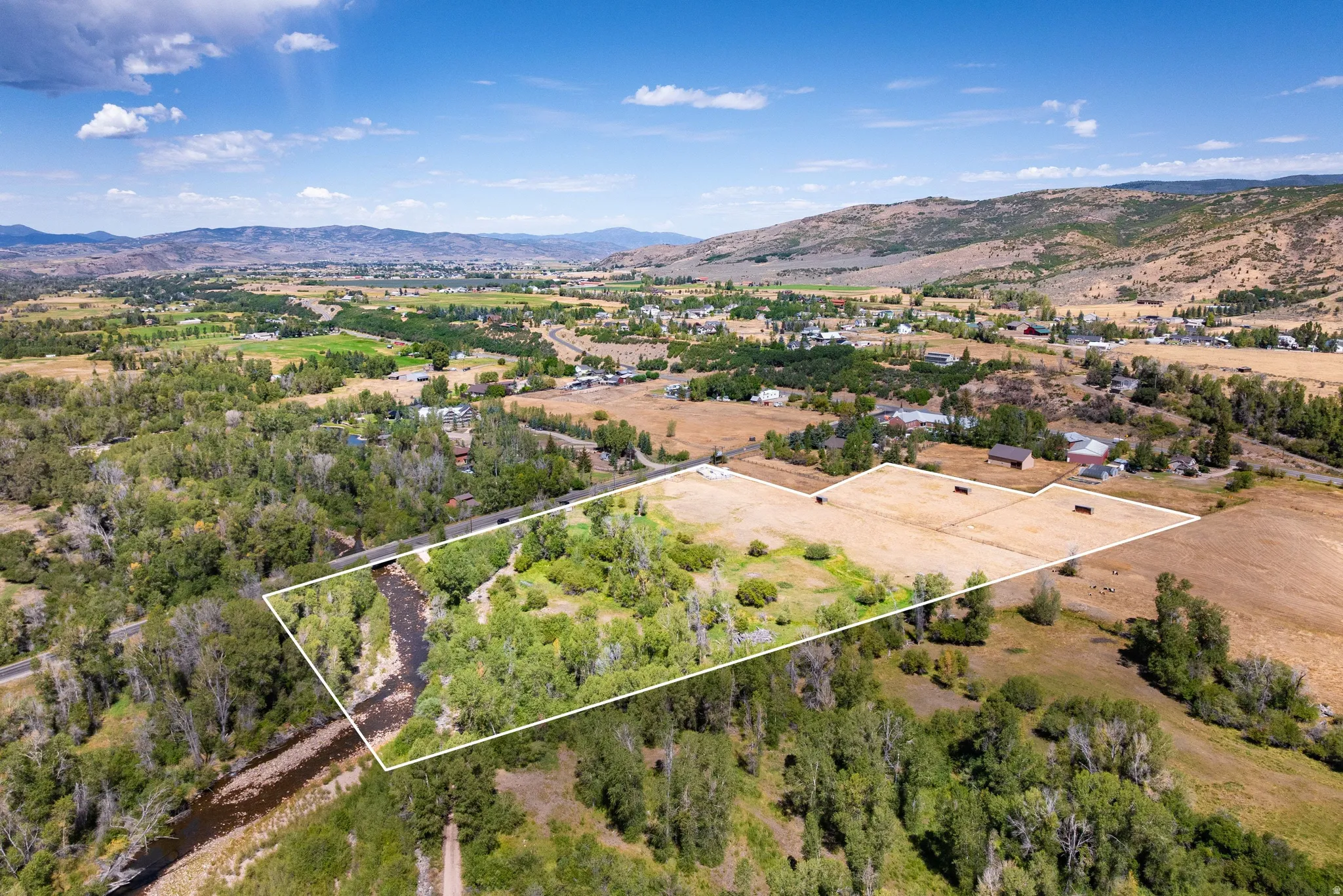 Expansive property featuring a natural river, surrounding mature trees, and open land areas