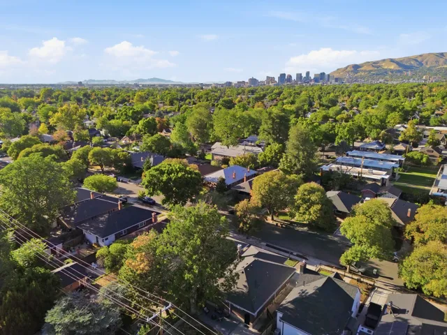 Expansive neighborhood setting with mature trees and mountain backdrop