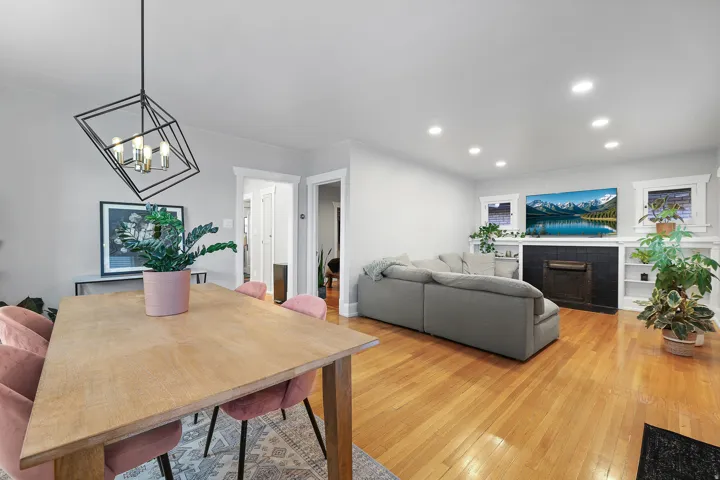 Newly installed recessed lighting, wood-finish flooring, built-in shelving, black tile fireplace surround