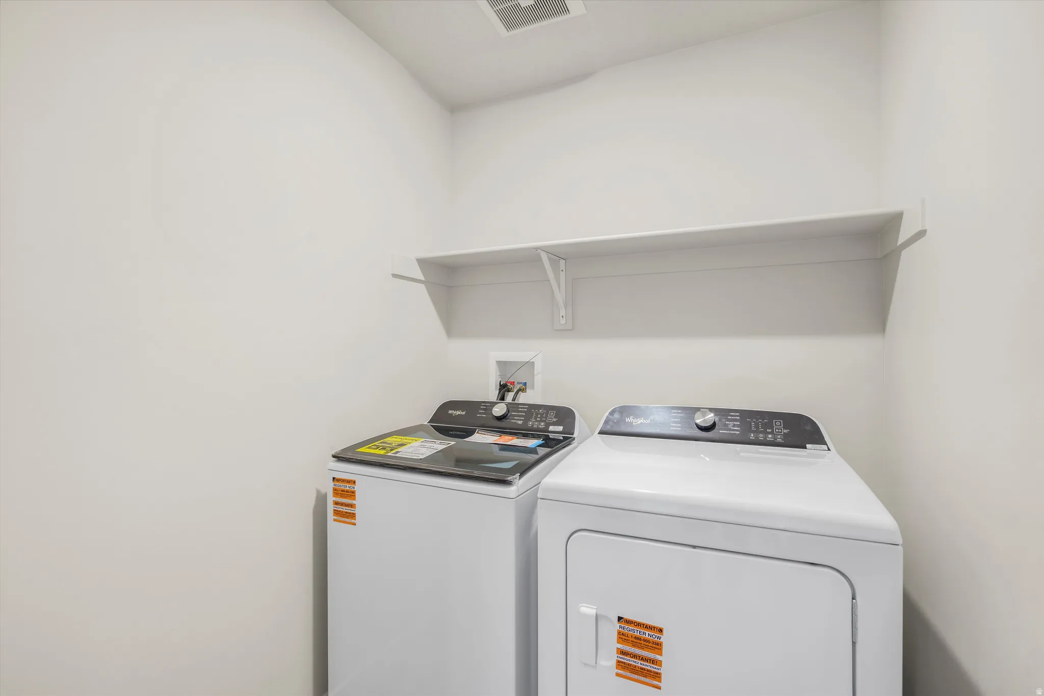 Laundry area featuring a wall-mounted shelf