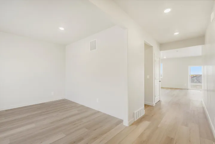 Wood-finish flooring throughout, recessed lighting, and bright white walls