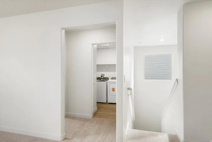 Dedicated laundry area with shelving and wood-finish flooring