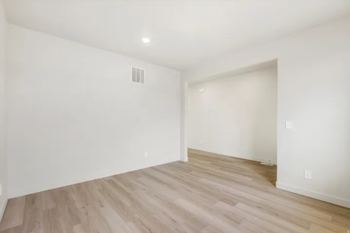Recessed ceiling lighting, light wood-finish flooring, white walls, and a wide entryway