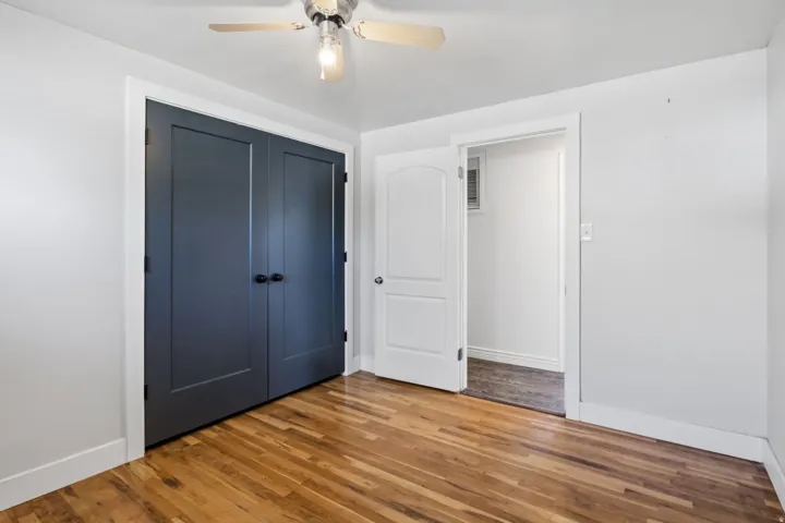 Wood-finish flooring, ceiling fan, and flat panel closet doors