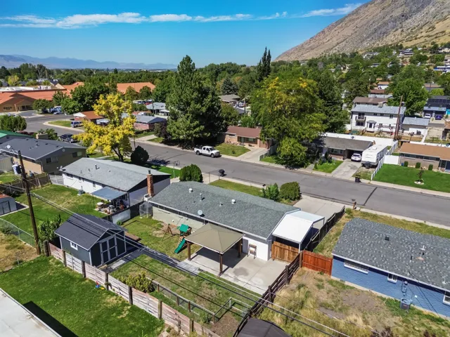 Single-story residence featuring a covered patio, a detached storage shed, and a paved driveway