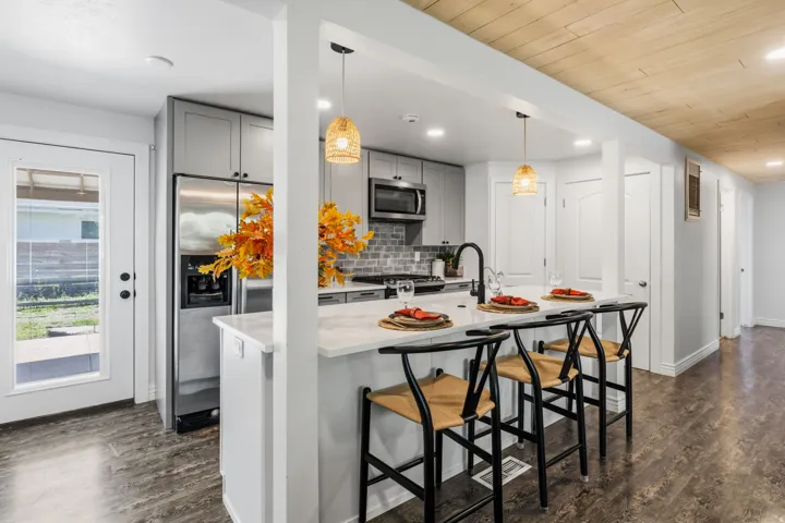 Kitchen with light gray cabinetry, stainless steel appliances, and a tile backsplash