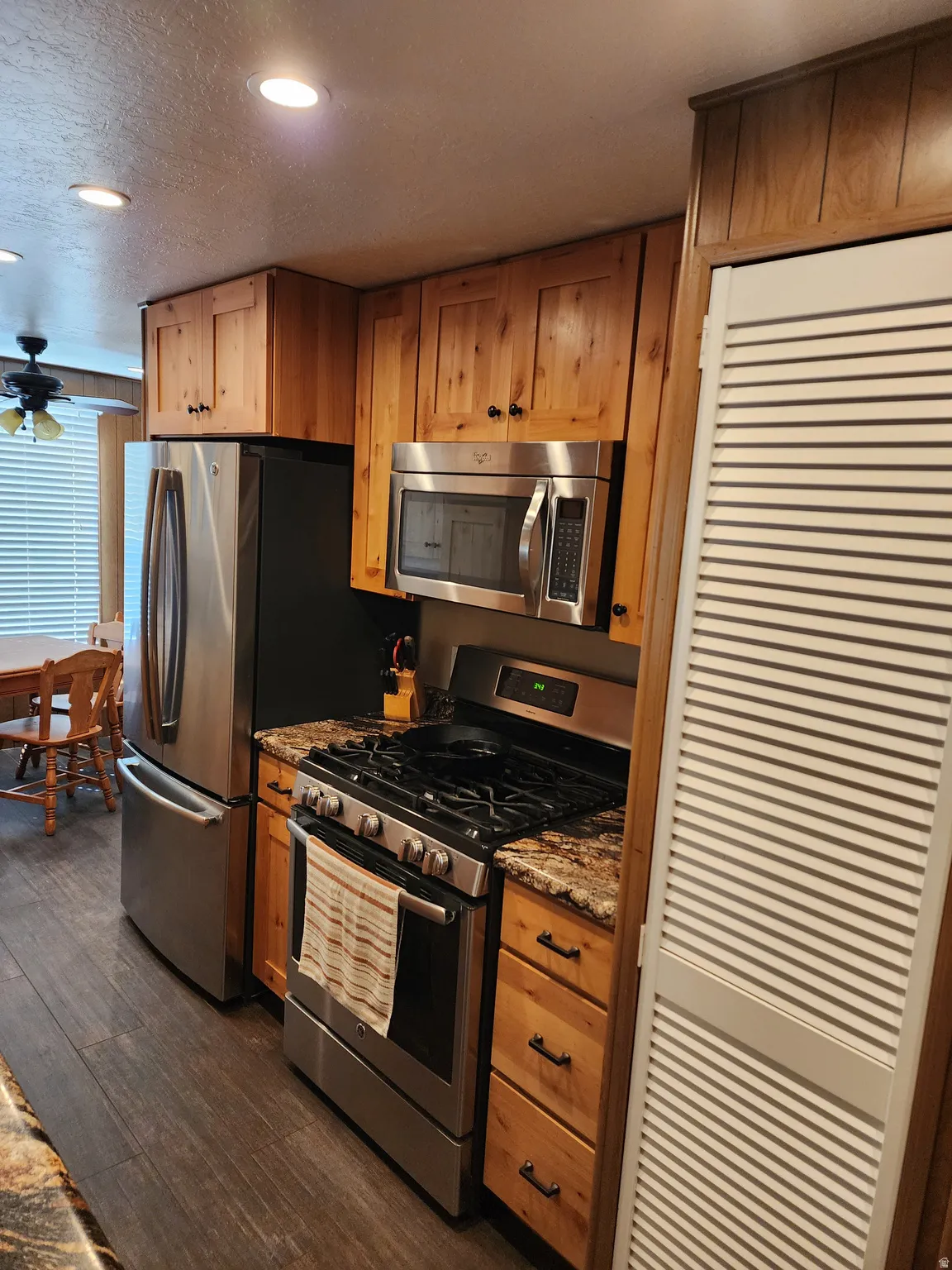 Kitchen featuring wood cabinetry, stainless steel appliances, recessed lighting, and wood-finish flooring