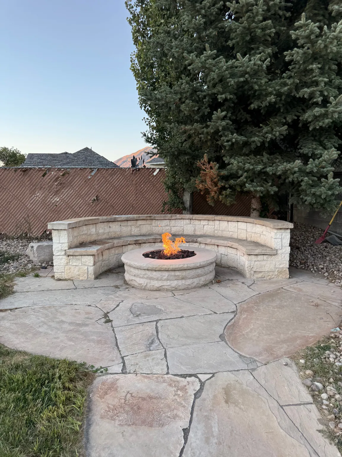 Stone patio featuring a built-in fire pit and curved stone bench seating