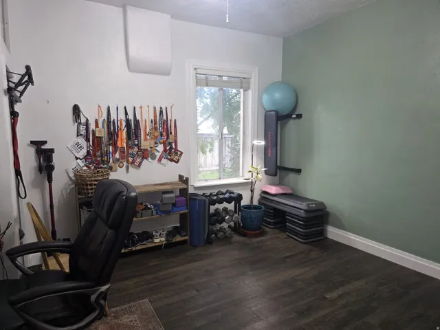 Wood-finish flooring with white trim and a window
