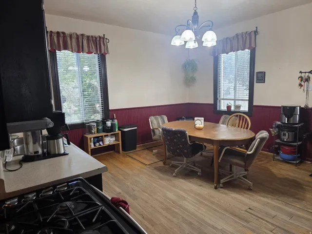 Wood-finish flooring, white walls, and red wainscoting