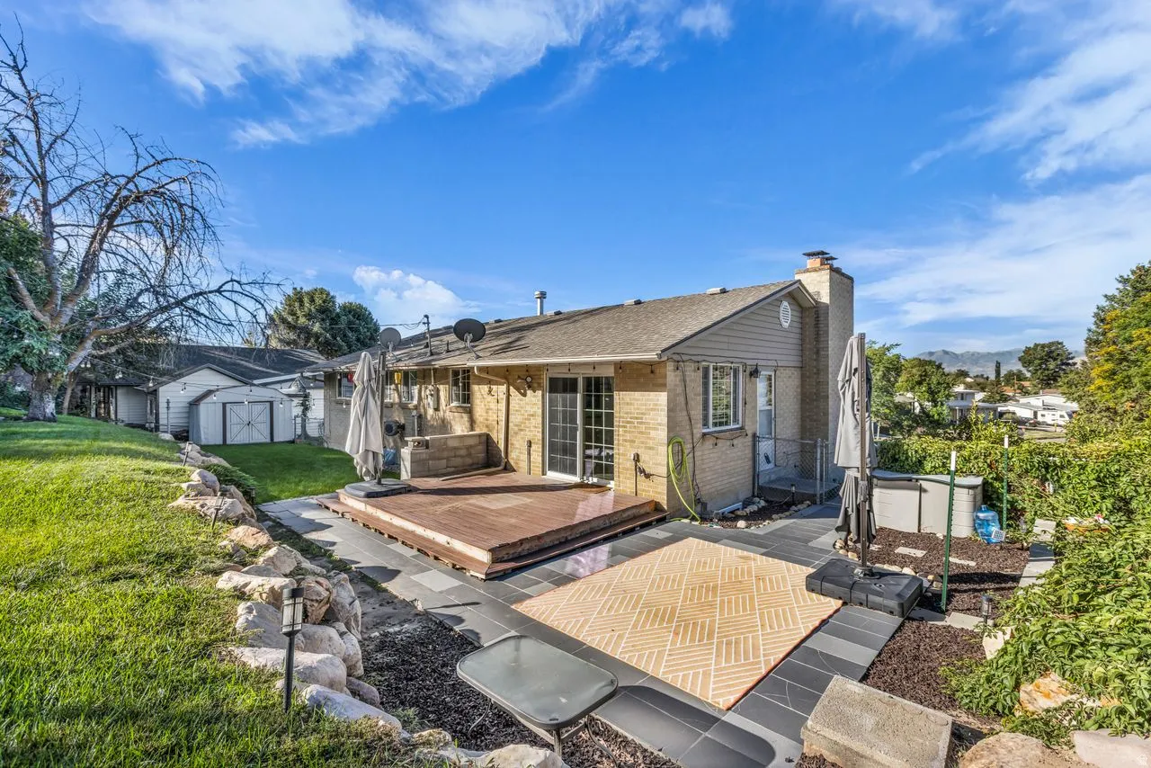 Expansive patio with multi-level decking, direct access to the interior, and a manicured lawn