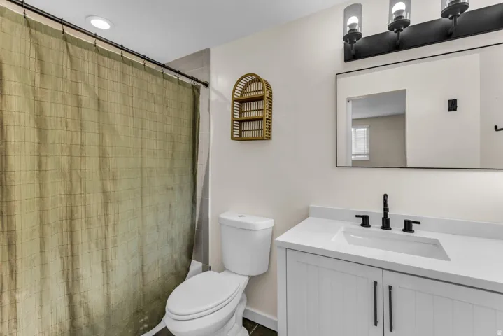 White vanity with shaker-style door fronts, integrated sink, and dark hardware