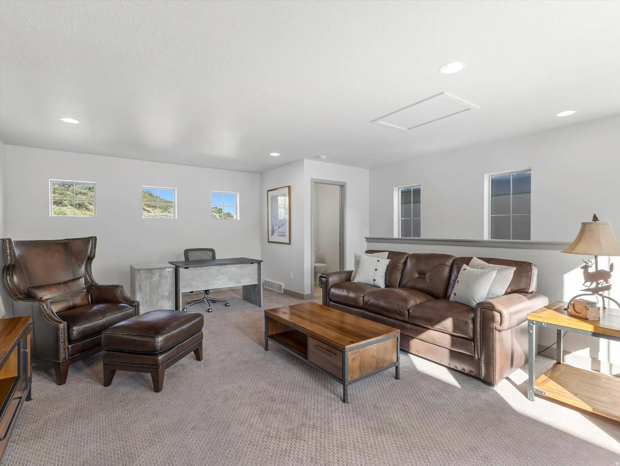 Recessed lighting, multiple windows, and light gray wall paint
