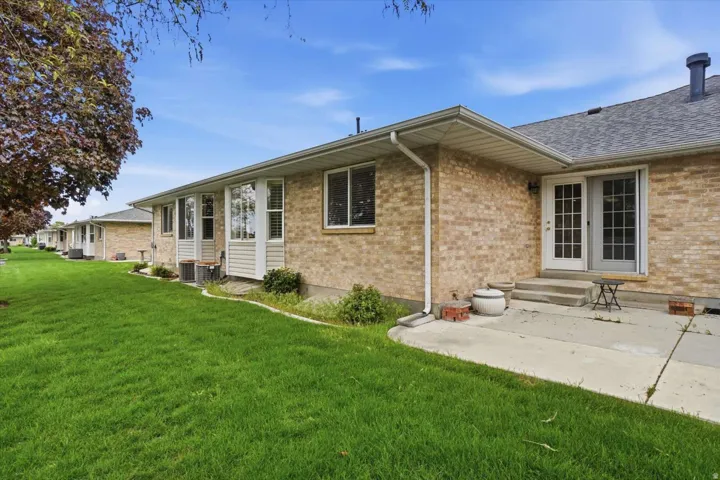 Brick exterior with a gray shingle roof and white gutters