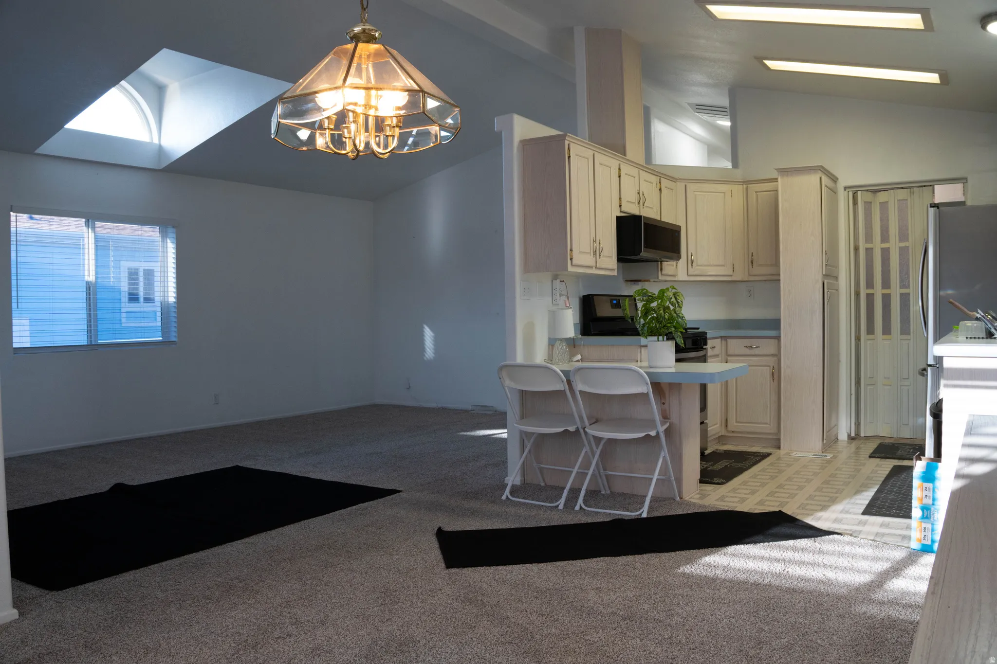 Vaulted ceilings, skylight, recessed lighting, built-in cabinetry, and tile flooring
