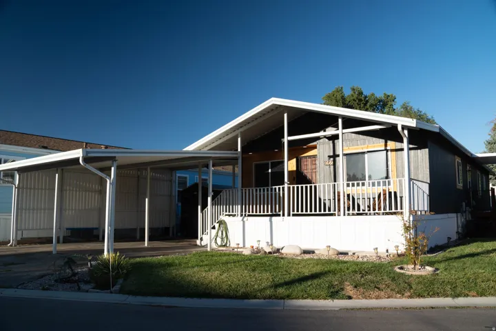 Exterior featuring a covered carport, covered porch with white railing, and horizontal siding