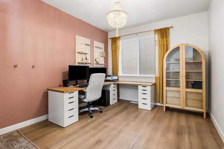 Wood-finish flooring, white trim, and a window with blinds