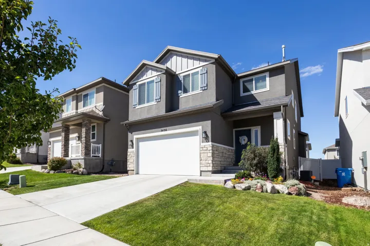 Two-story stucco and stone-finish exterior with an attached two-car garage