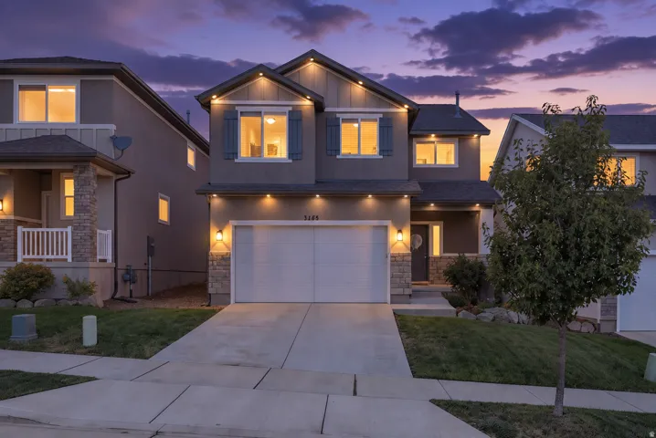 Contemporary two-story exterior with stone veneer accents, an attached two-car garage, and a covered front entry