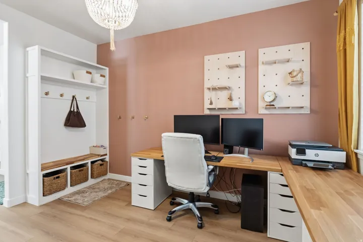 Built-in entryway storage with bench, wood-finish flooring, and chandelier lighting