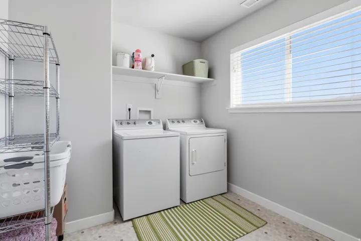 Dedicated laundry area featuring a window, built-in shelving, and a tiled floor