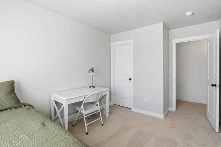 Neutral wall tones, white trim, and carpeted flooring