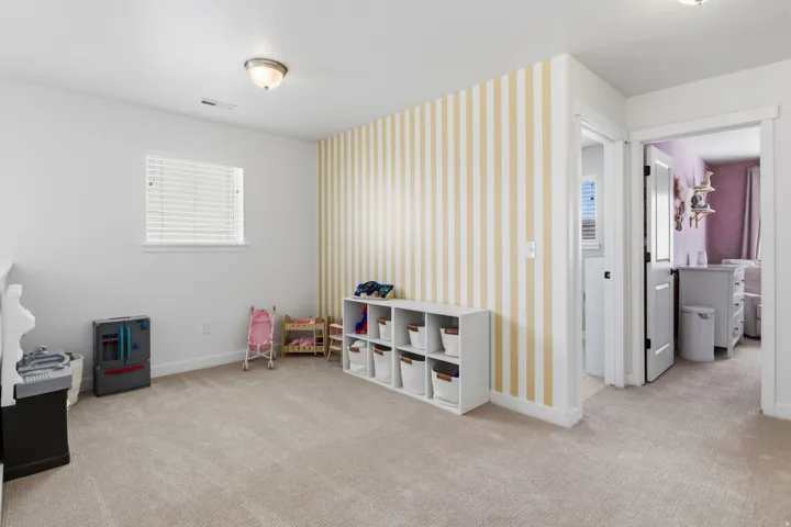 Carpeted room with a rectangular window, overhead flush mount lighting, and a striped accent wall