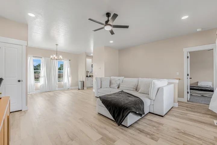 Recessed lighting, wood-finish flooring, ceiling fan, and a contemporary chandelier