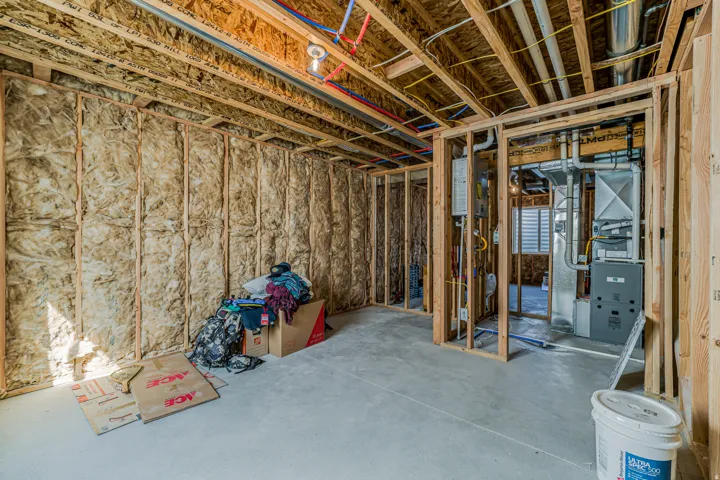 Framed interior space with exposed ceiling joists, insulated wall cavities, and concrete flooring