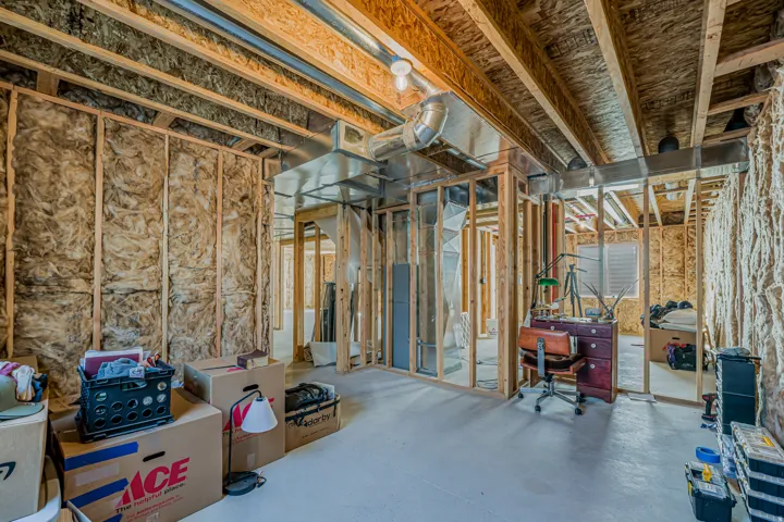 Unfinished basement space with exposed wood framing, ceiling joists, and wall insulation