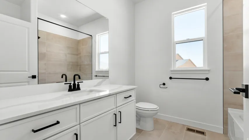 White vanity with integrated sink and matte black faucet