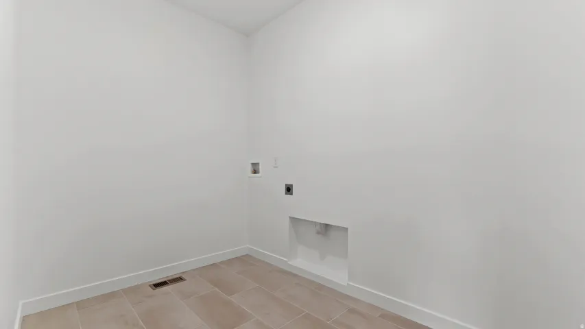 Tiled flooring, white wall paint, and utility connections