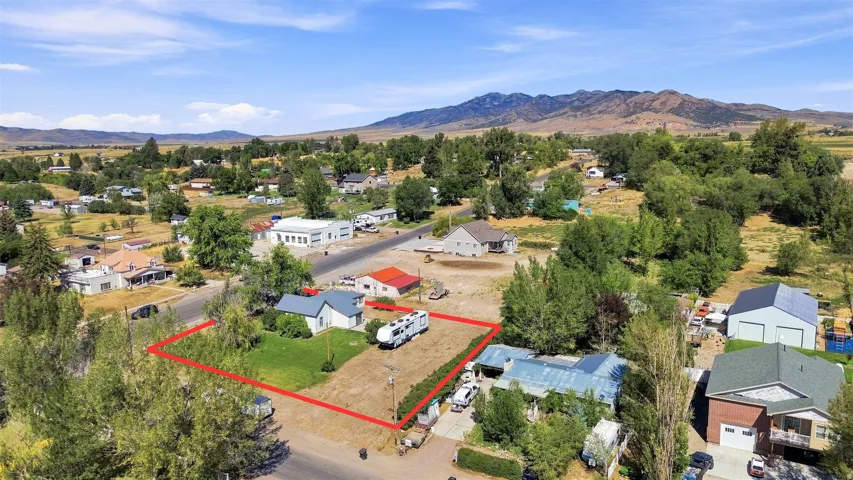 Level lot featuring a partial grass area and surrounding mature trees
