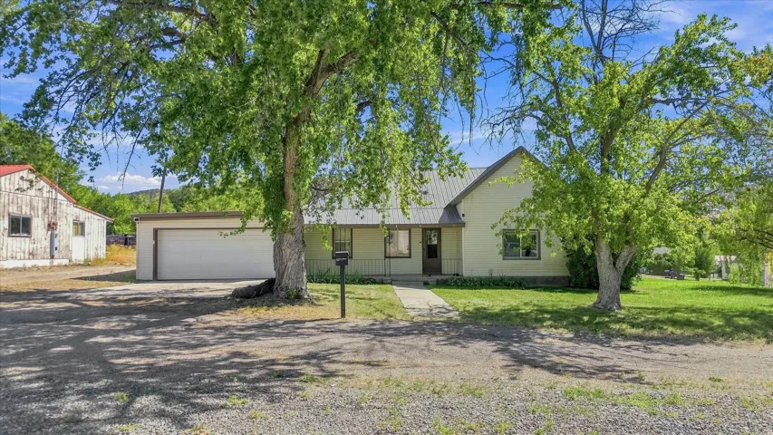 Single-story residence featuring a covered front porch, an attached two-car garage, and a metal roof