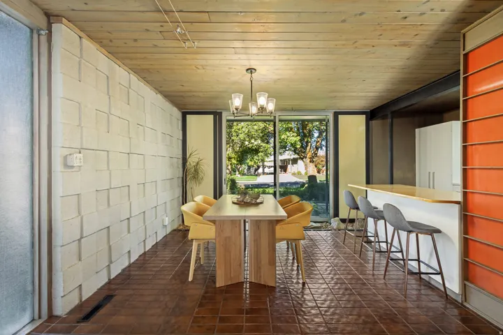 Open-concept dining area featuring a wood plank ceiling and tiled flooring