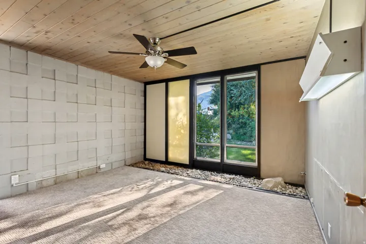 Wood-paneled ceiling with a central ceiling fan
