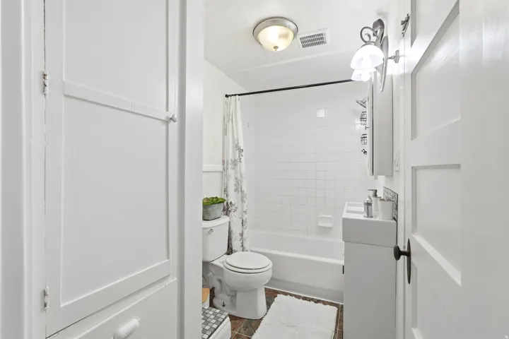 White subway tile shower surround with a white tub